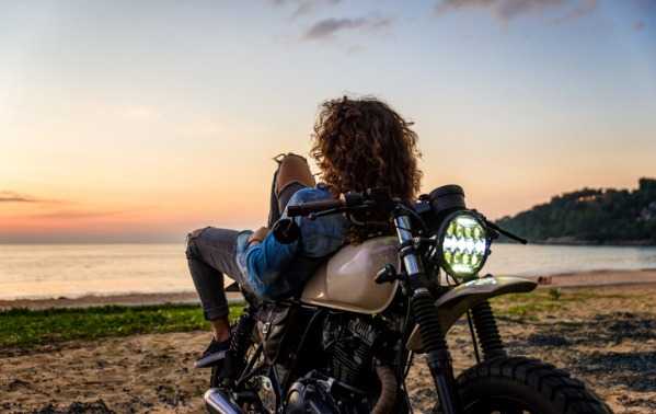 Mujer apoyada en una moto 